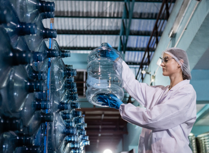 female worker holding checking quality of large bottle
